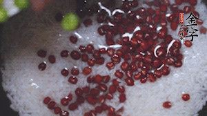 將炒好的食材和大米、紅豆一起放進(jìn)電飯鍋煮。