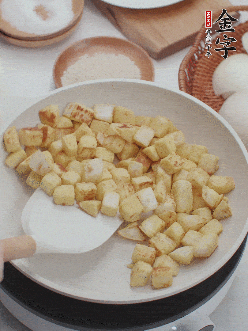 起鍋熱油，倒入饅頭丁，小火煎至蛋液凝固定型再翻面，饅頭丁部煎至金黃時盛起待用。