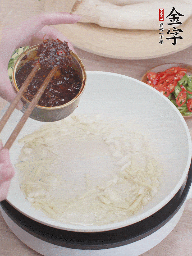 起鍋熱油，姜蒜、金字火腿干貝醬煸香。