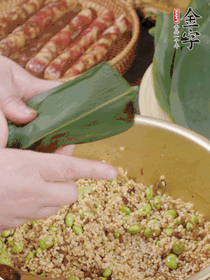 粽葉往下折，完全蓋住，兩側(cè)捏緊。