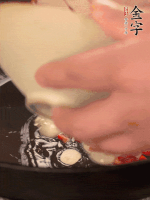 豬油潤(rùn)鍋，下辣椒、大蒜、火腿片煸香。