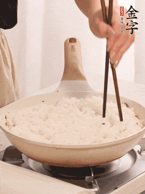 把瀝干水分的米飯均勻鋪在上面，筷子戳幾個(gè)洞，以便透氣，轉(zhuǎn)小火蓋上蓋子燜至水分收干，大概10分鐘。