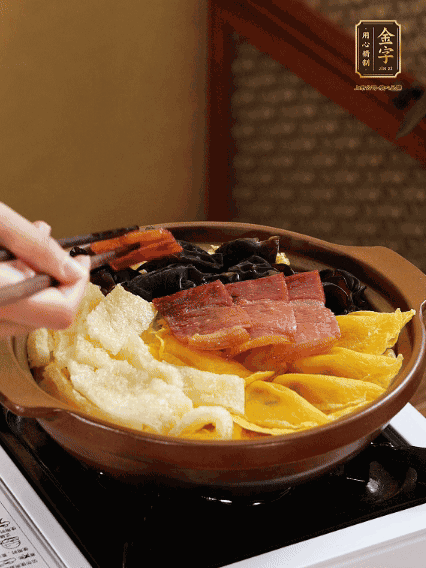 砂鍋底部鋪上娃娃菜，依次擺上肉皮、蛋餃、黑木耳、火腿